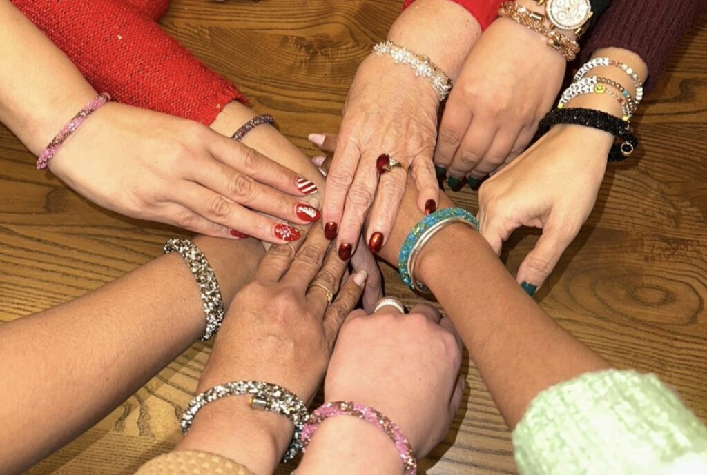 Diverse close up of many female hands touching in the center.
